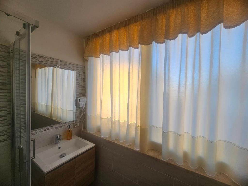 uma casa de banho com um lavatório e um espelho em Golden house sicily em Catânia