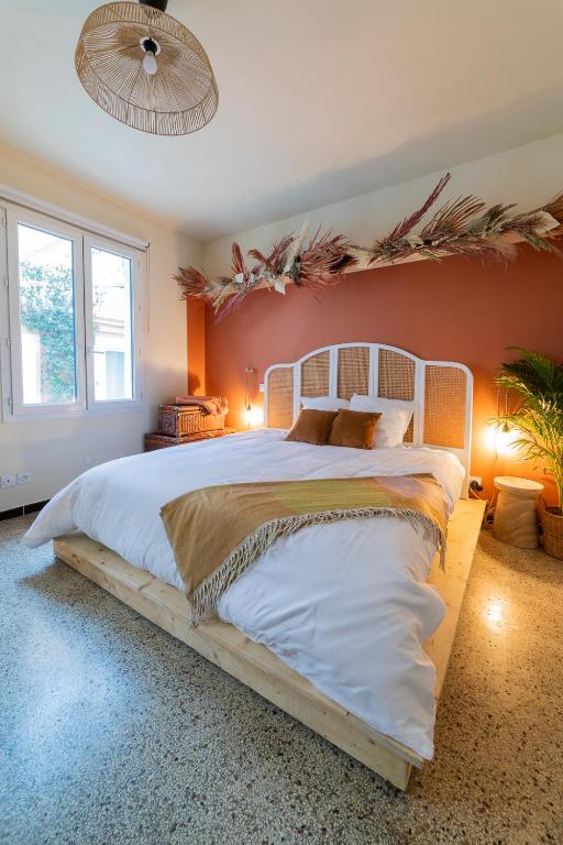 - une chambre avec un grand lit et un cadre en bois dans l'établissement Un petit nid douillet, à Montpellier