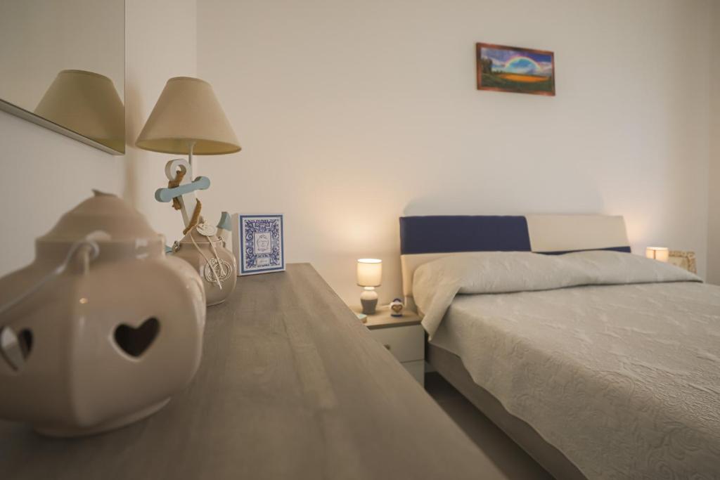 een slaapkamer met een bed en een tafel met een lamp bij Paolino Housing in Paestum
