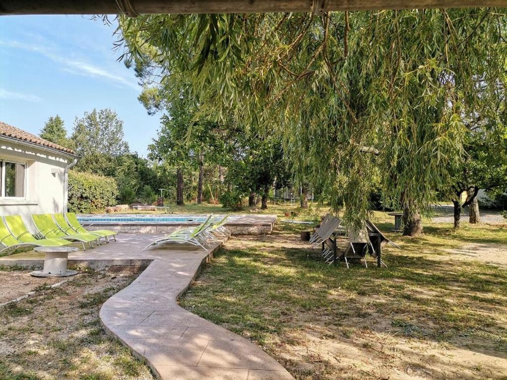 a swimming pool with benches and a tree at les papillons in Ruoms