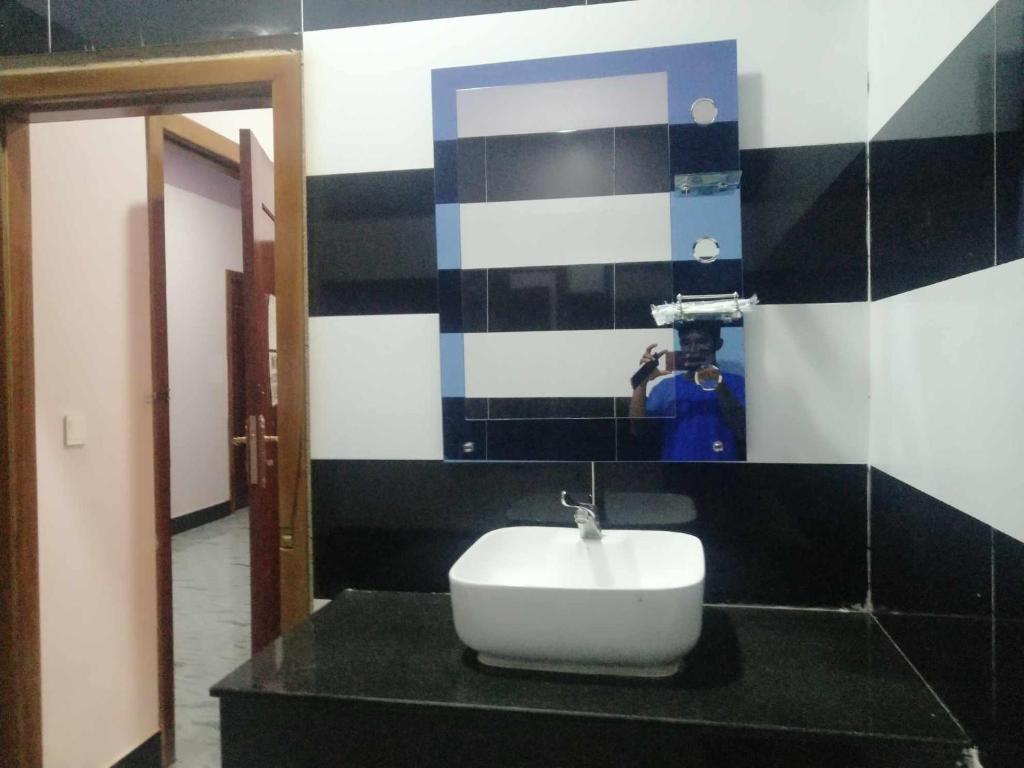 a person taking a picture of a sink in a bathroom at The Vibe Guesthouse in Kampot