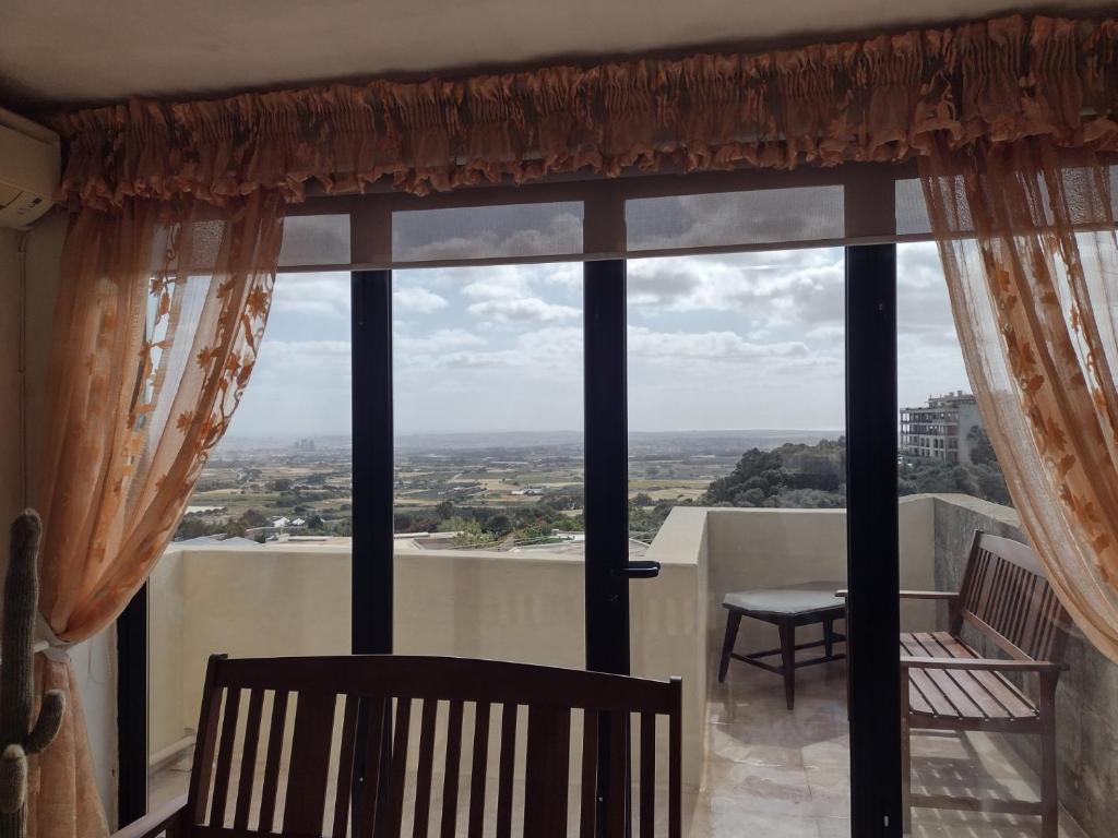 ein großes Fenster mit Stadtblick in der Unterkunft Terraced house with stunning view close to Mdina in Rabat