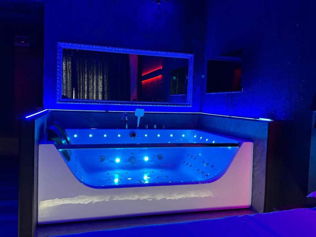a blue bathroom with a tub with lights in it at Nubia studios & spa in Bucharest