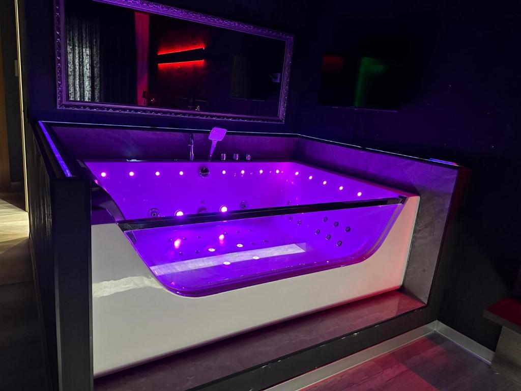 a purple bath tub with lights in a bathroom at Nubia studios & spa in Bucharest