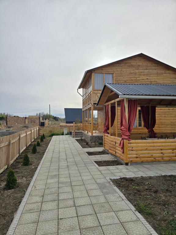 Cabaña de madera con pasarela junto a un edificio en WooD_House_Issyk-Kul, en Bosteri