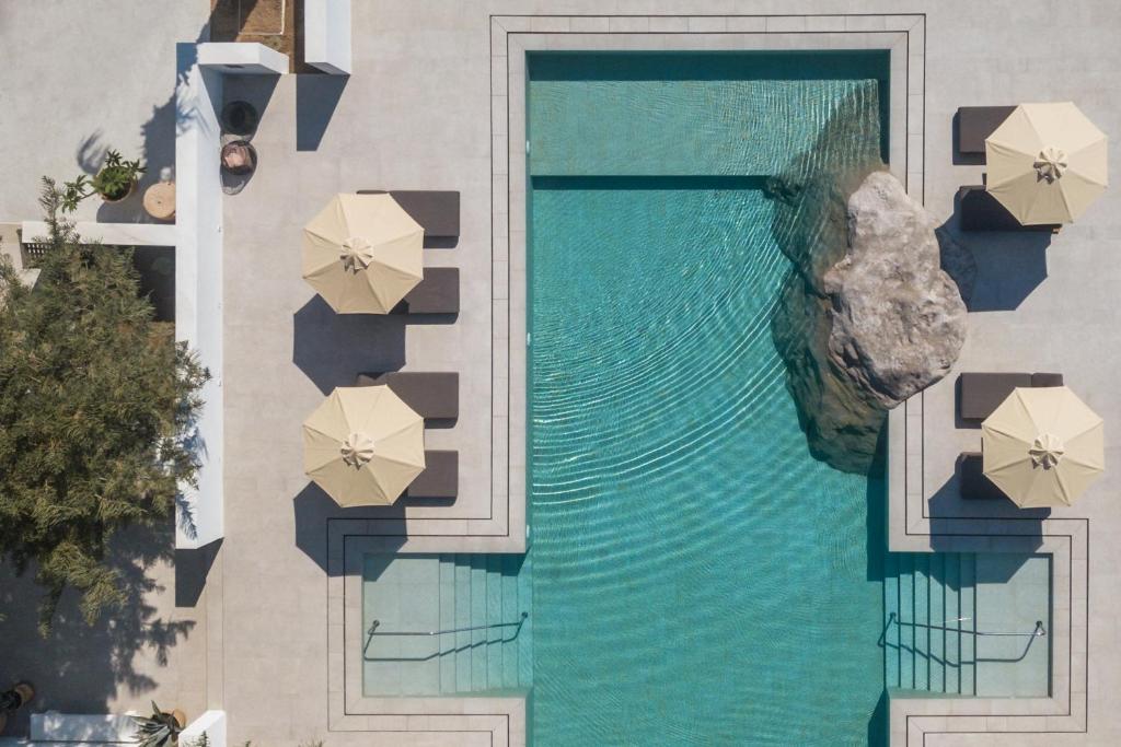 an overhead view of a swimming pool with umbrellas at Parilio, a Member of Design Hotels in Naousa