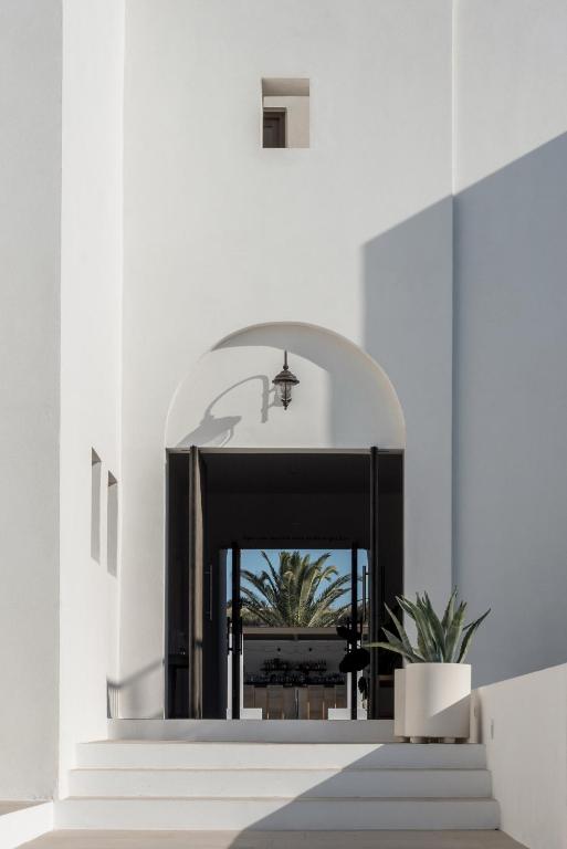 a hallway with stairs and a mirror in a building at Parilio, a Member of Design Hotels in Naousa