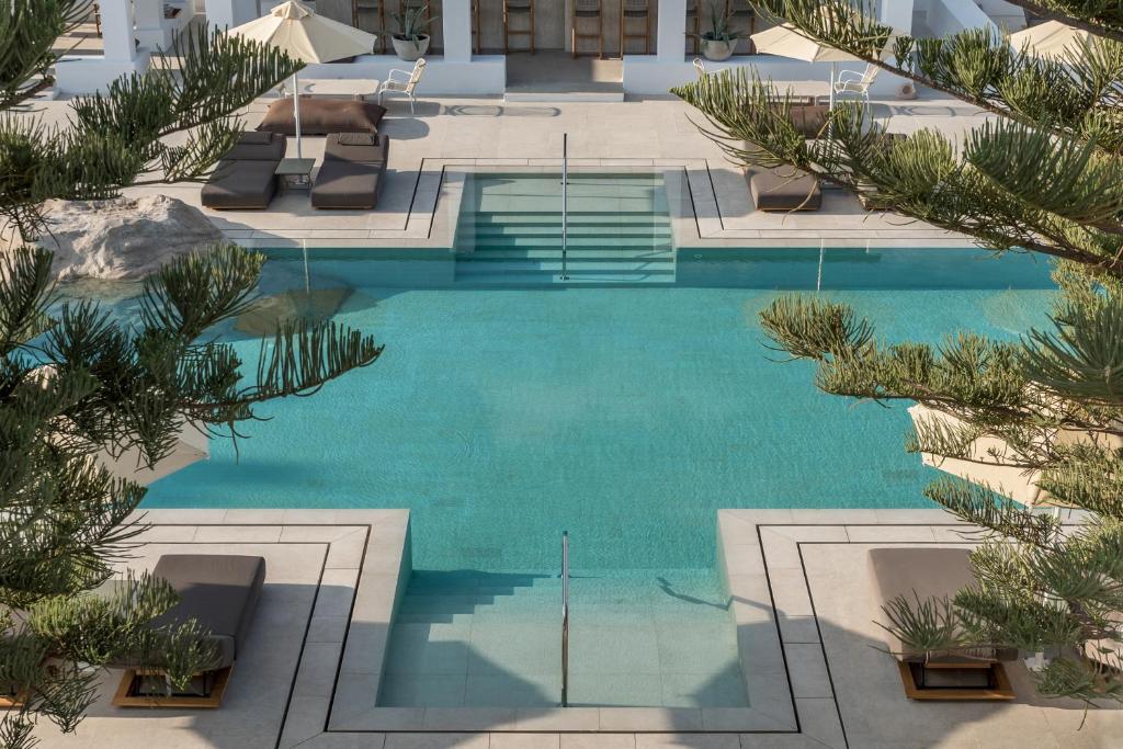 an overhead view of a swimming pool with palm trees at Parilio, a Member of Design Hotels in Naousa
