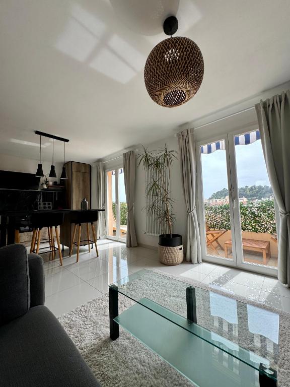 - un salon avec une table en verre et un piano dans l'établissement Dernier étage, vue panoramique Colline du Château!, à Nice