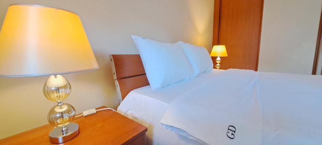 una camera con letto e lampada sul comodino di Golden Delight Central Apartment a Skopje