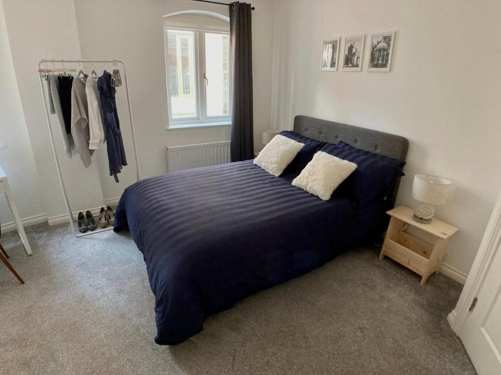 a bedroom with a blue bed with two pillows at Emily Lane Apartments in Belfast