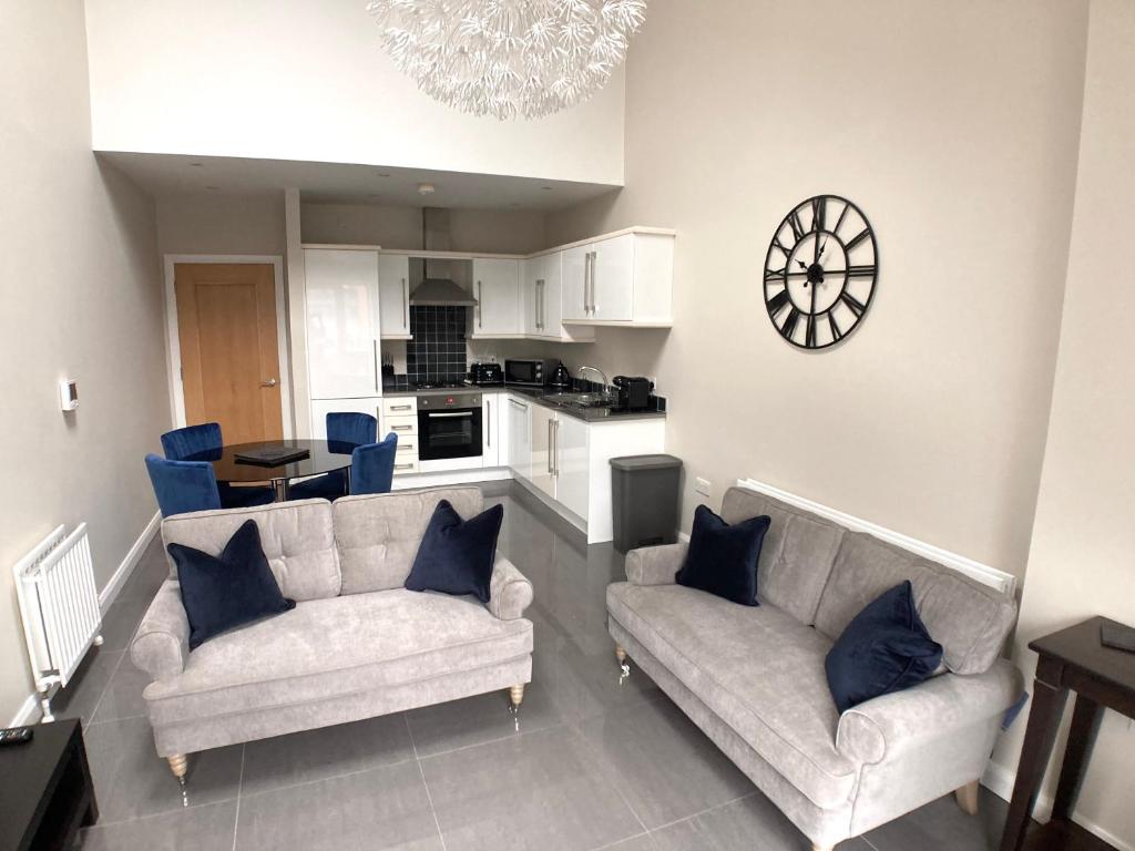 a living room with two couches and a kitchen at Cathedral Quarter Apartments in Belfast