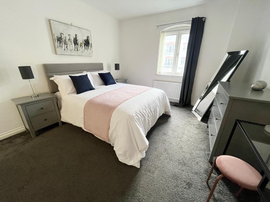 een slaapkamer met een bed, een dressoir en een televisie bij Academy Street Apartments in Belfast