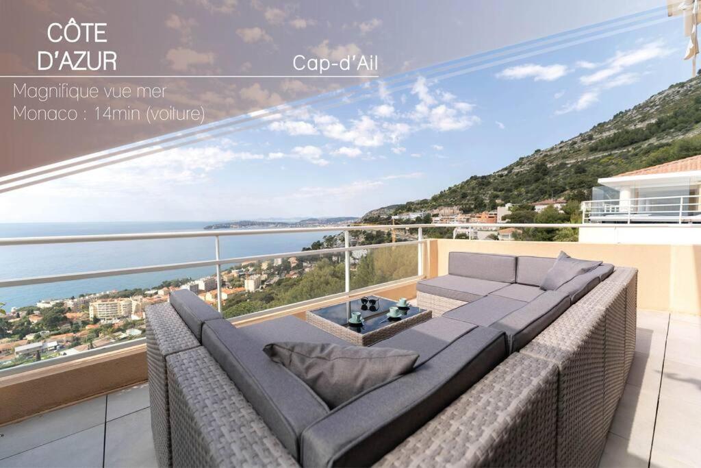 un salon avec un canapé et une vue sur l'océan dans l'établissement Magnifique appartement vue mer, piscine, garage, à Cap d'Ail