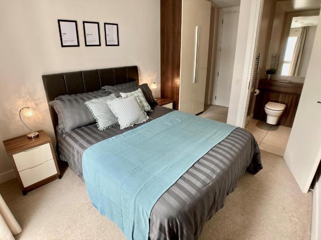 a bedroom with a large bed with a blue blanket at Hamilton Road Apartments in Belfast