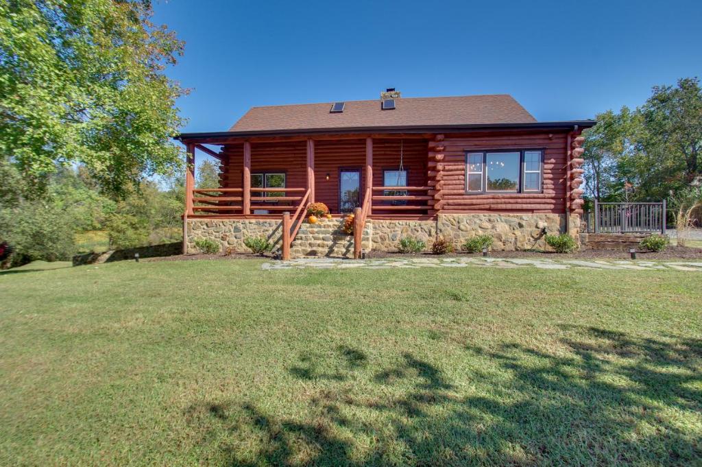 una cabaña de madera con un gran patio delante en Cozy Log Cabin Getaway with Fire Pit and 3 Acres!, en Ruckersville