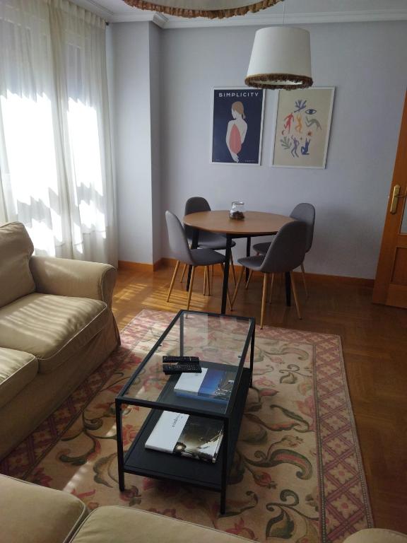 a living room with a couch and a table at Céntrico apartamento Oviedo Parking y wifi gratuitos Admite mascotas in Oviedo