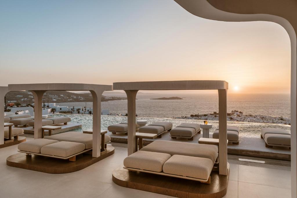 a room with a bunch of beds on the beach at Lovia Mykonos in Mýkonos City