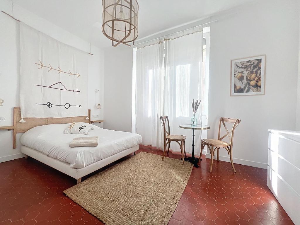 une chambre avec un lit, une table et des chaises dans l'établissement - Maison ŪMA - Mer et centre -, à Marseille
