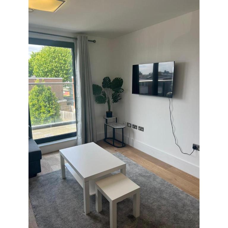 a living room with a white table and a window at Spacious 1 Bedroom Flat in Kilburn Park F55 in London