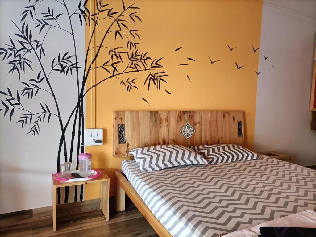 a bedroom with a bed with birds on the wall at Sai Homestay in Malvan