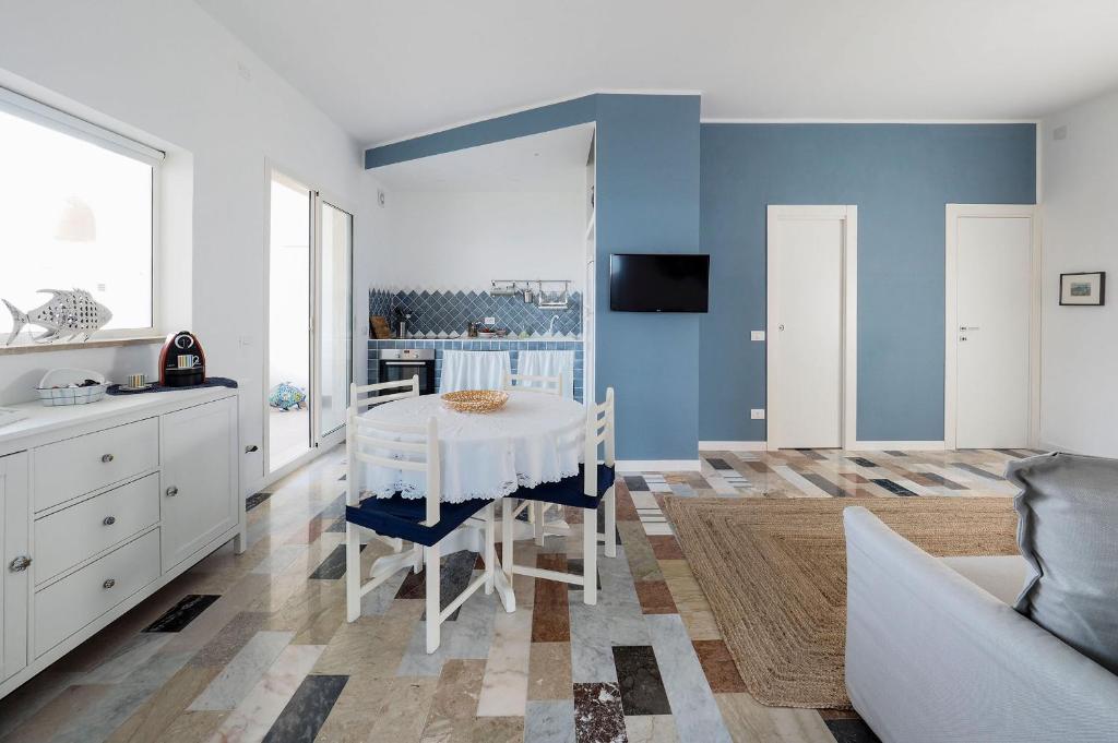una sala da pranzo con tavolo bianco e pareti blu di Rifugio a Mare a Calabernardo