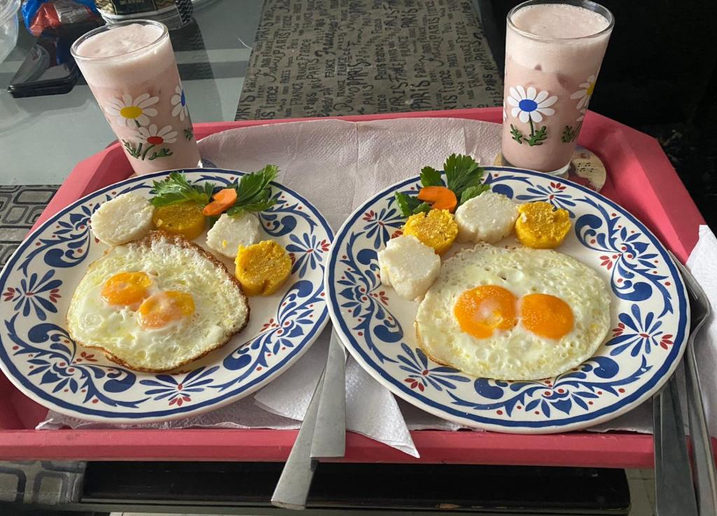 dos platos de huevos fritos en una bandeja roja en HOTEL MAR Y MAR, en Santa Marta