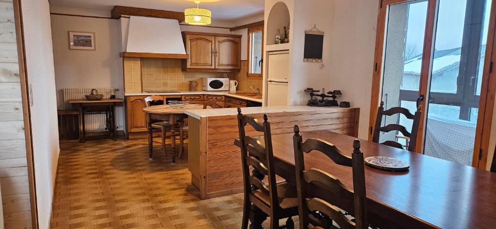 une cuisine avec une table en bois et une salle à manger dans l'établissement Appartement 3 chambres à la LLagonne, à La Llagonne