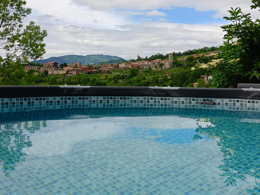 a large swimming pool with a view of a city at El Roure in Molló