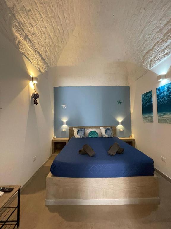 ein Schlafzimmer mit einem blauen Bett in einem Zimmer in der Unterkunft L'Ostrica in Ostuni
