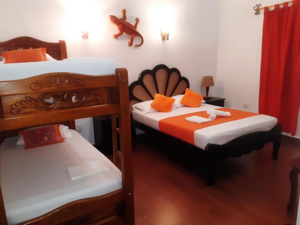 una camera con 2 letti a castello con lenzuola bianche e arancioni di Hotel Viajero Mompox a Mompós