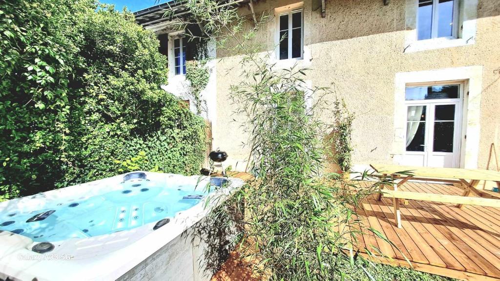 una bañera al lado de una casa en Domaine de Cachaou Villa Leyr'ial sauna & spa, en Salles