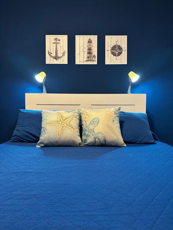 a blue bedroom with a bed with blue sheets and two lamps at BluMare ForFamily in Gallipoli
