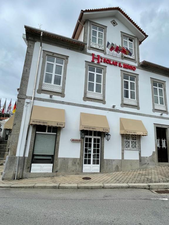 um edifício branco com uma placa de hotel em Solar S.Bento em Santo Tirso