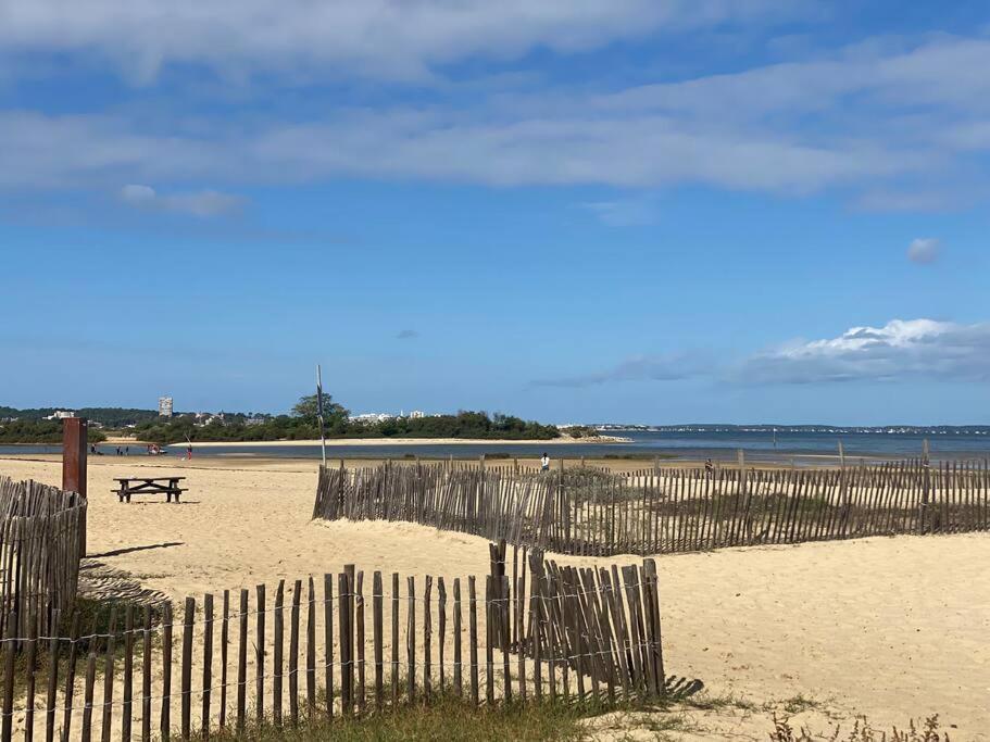une clôture sur une plage avec une table de pique-nique dans l'établissement Esprit Cabane La Hume - Terrasse & Vue sur le Port, à Gujan-Mestras