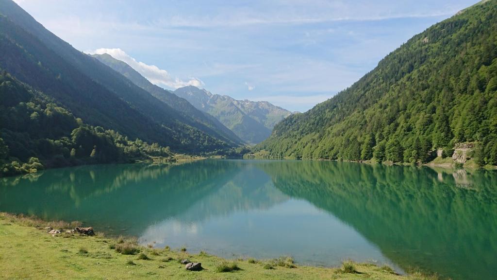 un lago en medio de un valle con montañas en Superbe logement 12 pers famille ou groupe., en Laruns