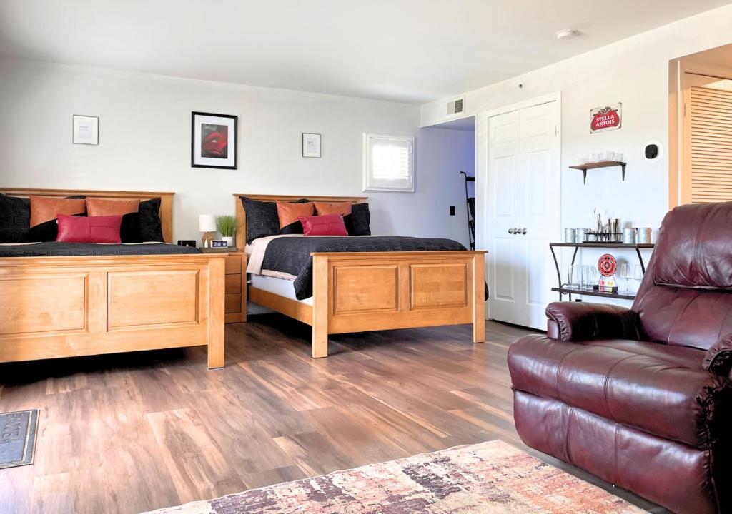 een slaapkamer met 2 bedden en een bank bij Getaway Villa- 3 mins to Mohegan- Fully Stocked with Two Full Beds & Fireplace- Jacuzzi, Saltwater Pools, Sauna in Norwich
