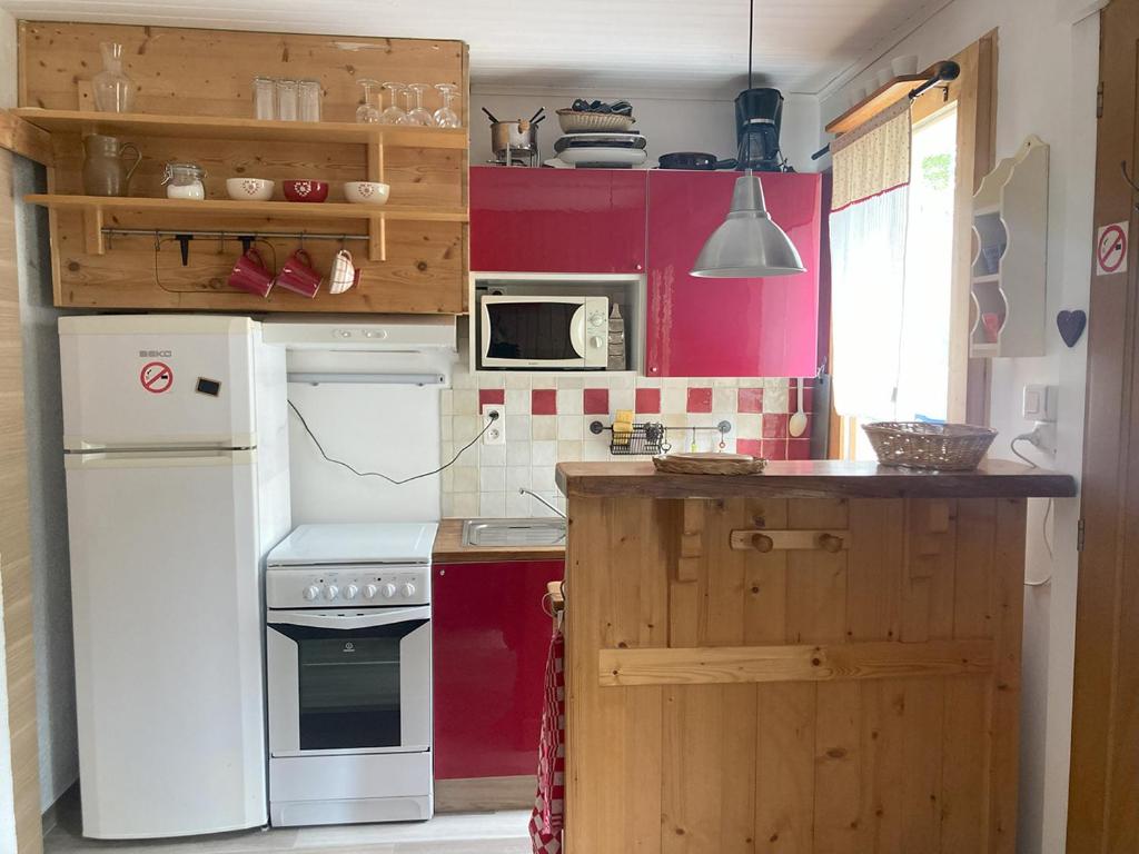 een keuken met een witte koelkast en rode kasten bij Chalet Rekiano à Samoens - 5 pers in Samoëns