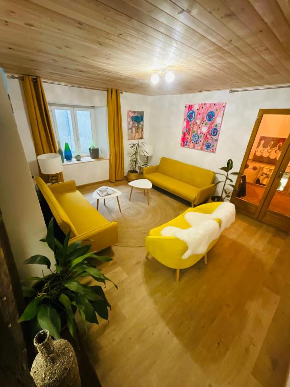 a living room with two yellow couches and a table at No 25 superbe apartment plein centre calme ,Netflix in Mirepoix