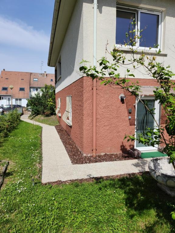 una casa con un patio de césped al lado de un edificio en Joli appartement individuel dans maison, en Ostwald