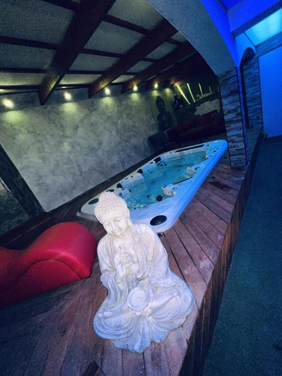 une baignoire avec une statue au milieu d'une pièce dans l'établissement Appartement Romantique L'Escapade Jacuzzi, à Espondeilhan