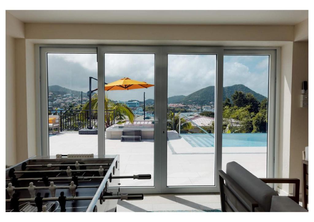 a room with a view of a pool and an umbrella at Oasis with Pool Hot Tub & Sauna in Rodney Bay Village