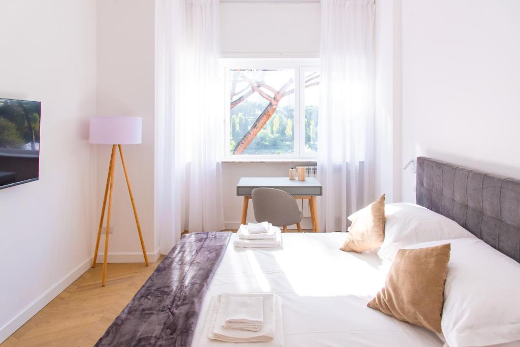 1 dormitorio con 1 cama con mesa y ventana en Eur terrazzo vista Laghetto Modigliani, en Roma