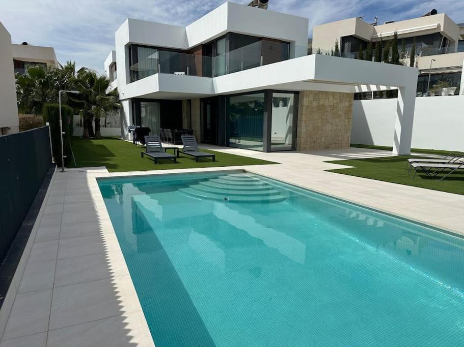 a house with a swimming pool in front of a house at Luksus i Alicante in Alicante