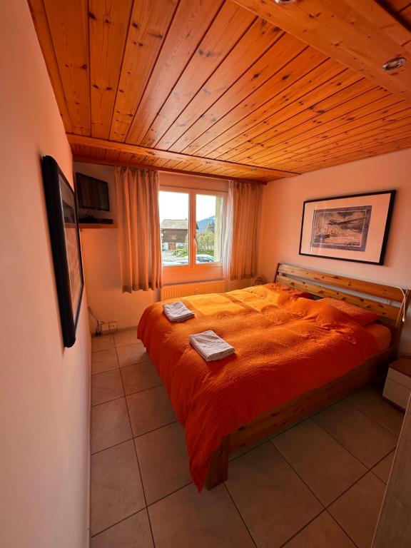 - une chambre avec un grand lit et un plafond en bois dans l'établissement Ferienwohnung Arvenbüel Bergtraum über Amden, à Amden