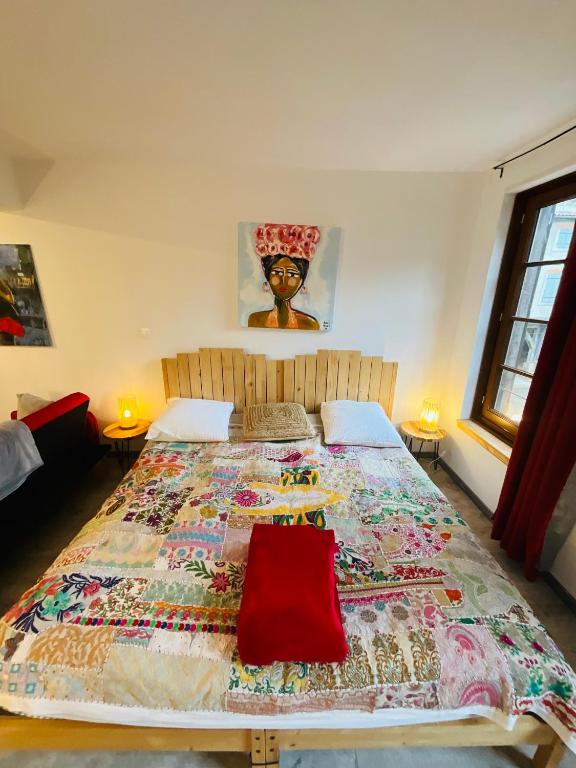 a bedroom with a large bed with a quilt on it at No 25 superbe apartment plein centre calme ,Netflix in Mirepoix