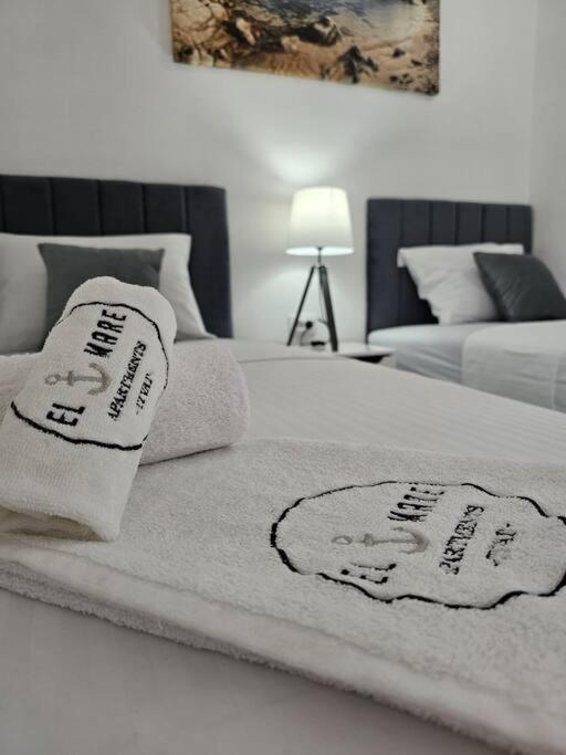 a white bed with towels on top of it at One-bedroom apartment, 5 min from the Airport Tivat in Mrčevac