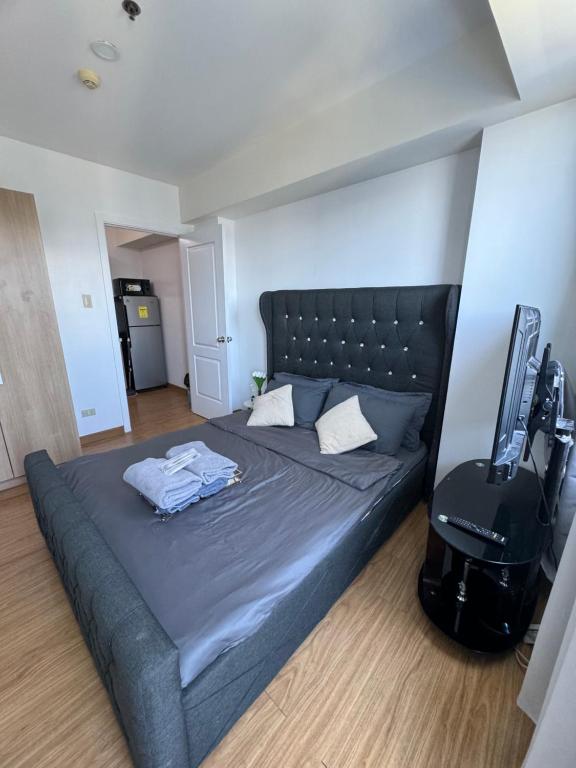 1 dormitorio con 1 cama y TV en Bias Haven Azure Urban Resort Residences en Manila