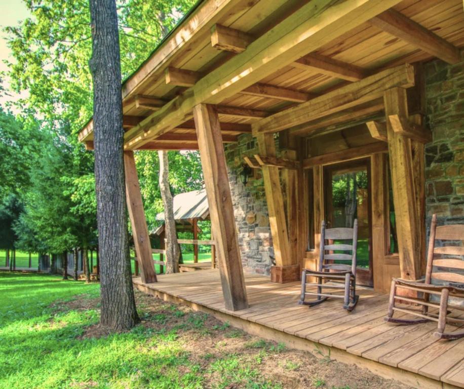 una veranda in legno di una cabina con due sedie sopra di Charming Bunkhouse, Private Porch, Double Shower a Franklin