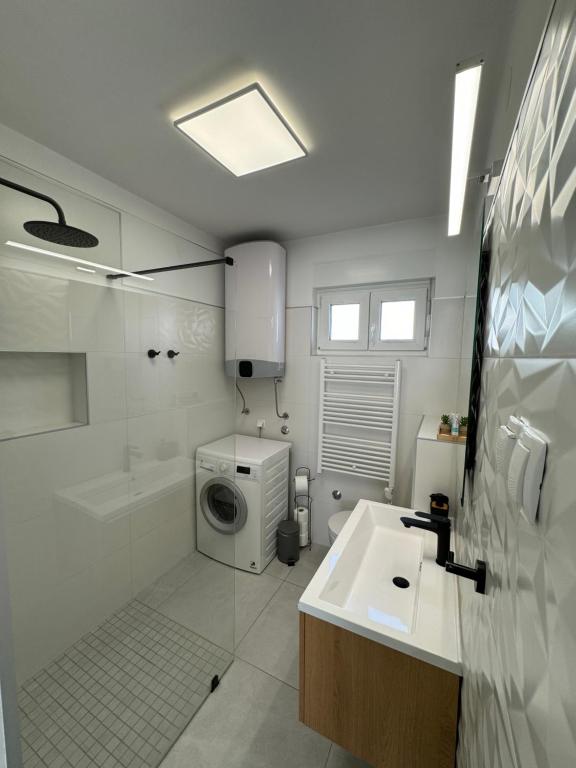 y baño con lavabo y lavadora. en Apartment Nono Marko, en Crikvenica